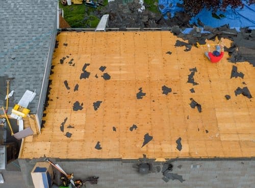 Roof tear-off in progress exposing decking during a roof repair by Build By Manny in Knoxville, TN